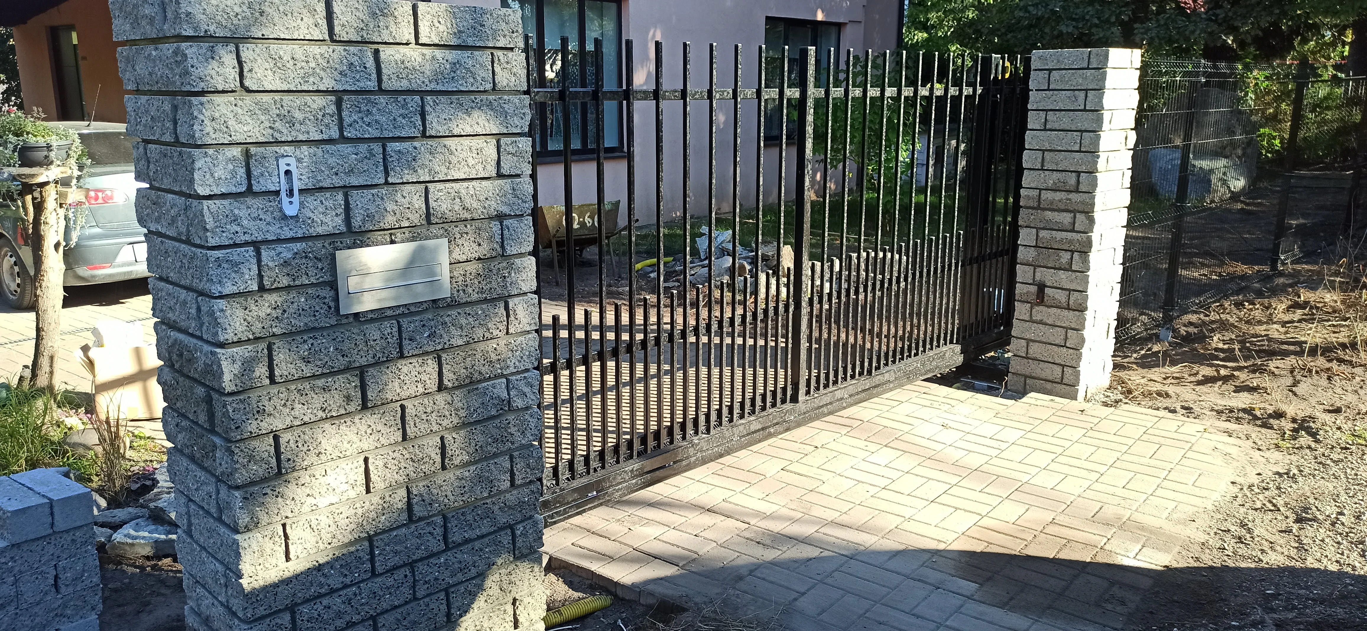 Kivipost - graniidist kiviposti vahel must metallvarbaed liugvärav