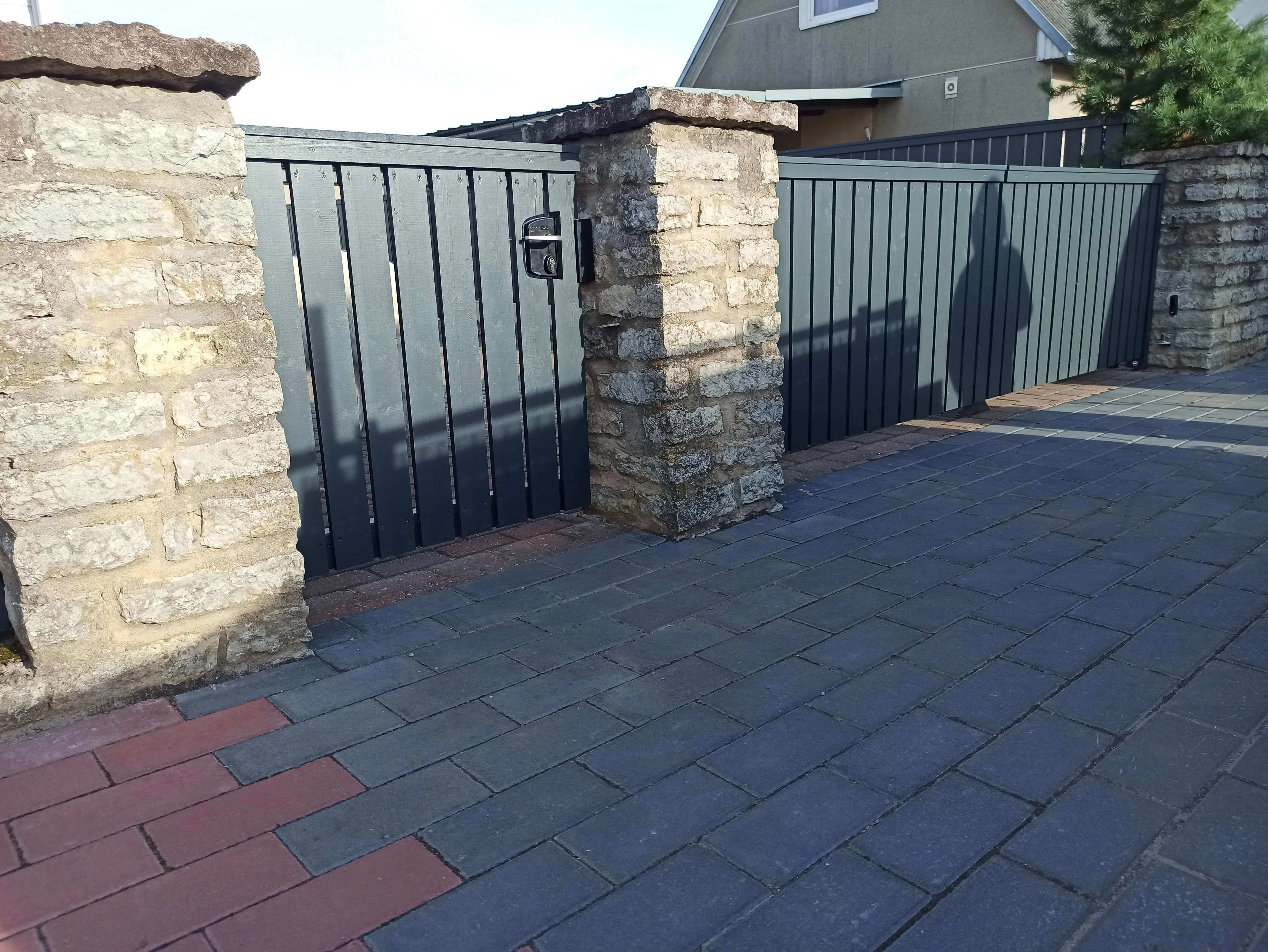 Kivipost - betoonpostid aiapiirdega eramu hoovis