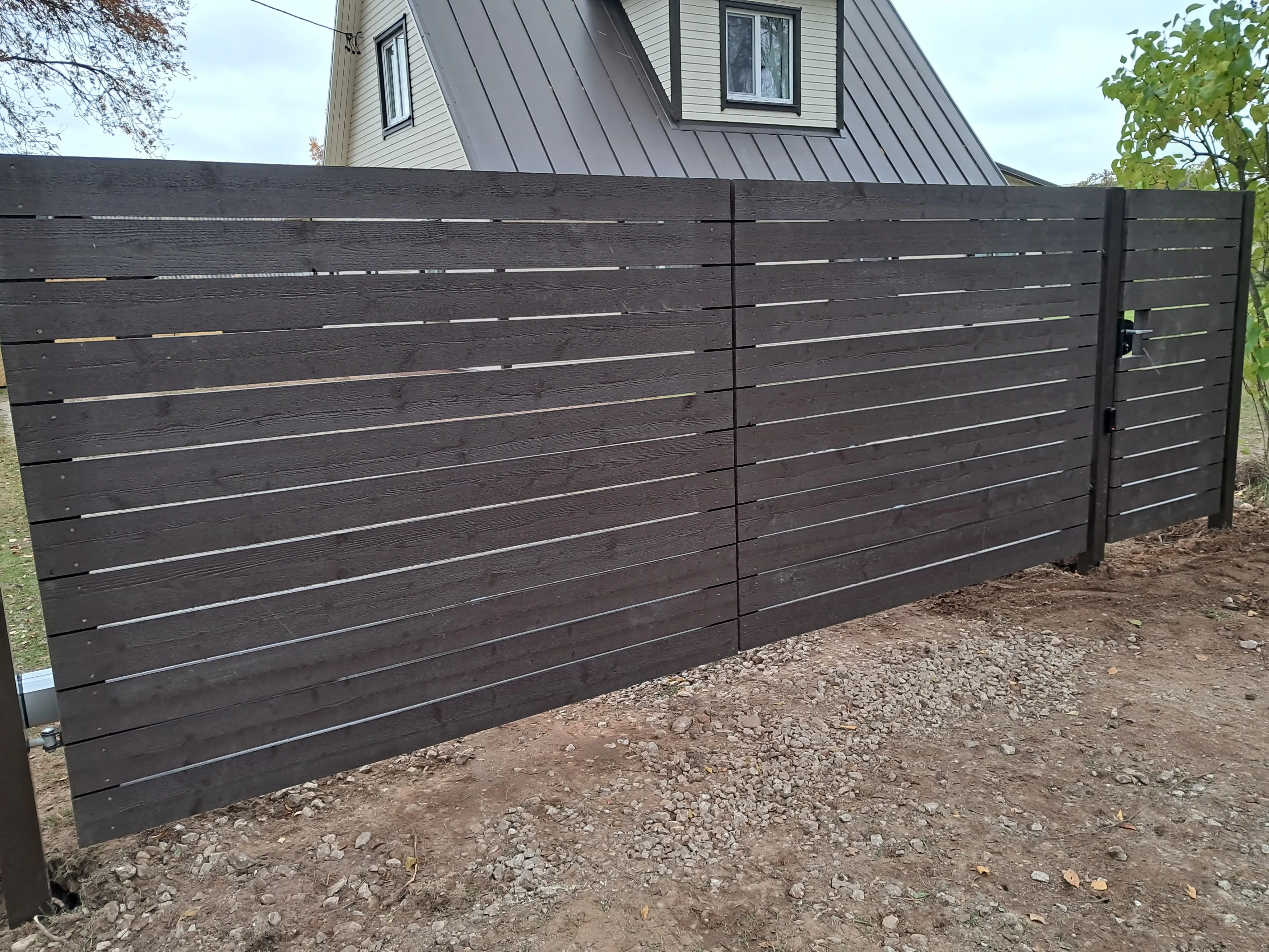 Puitaed - horisontaalne tumepruun laudis metalpostidega eramu hoovis