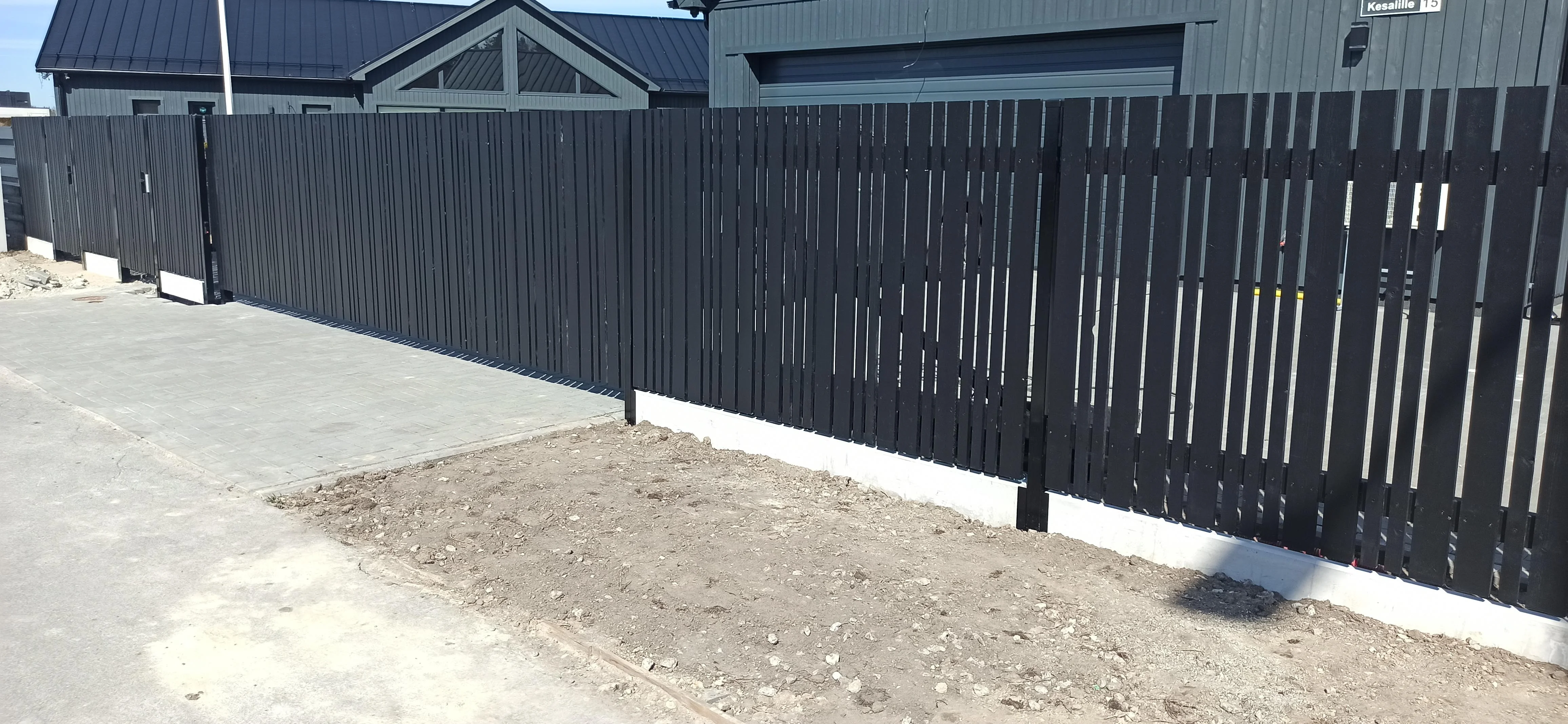 Puitaed - must vertikaalne laudis liugväravaga modernse hoone ees