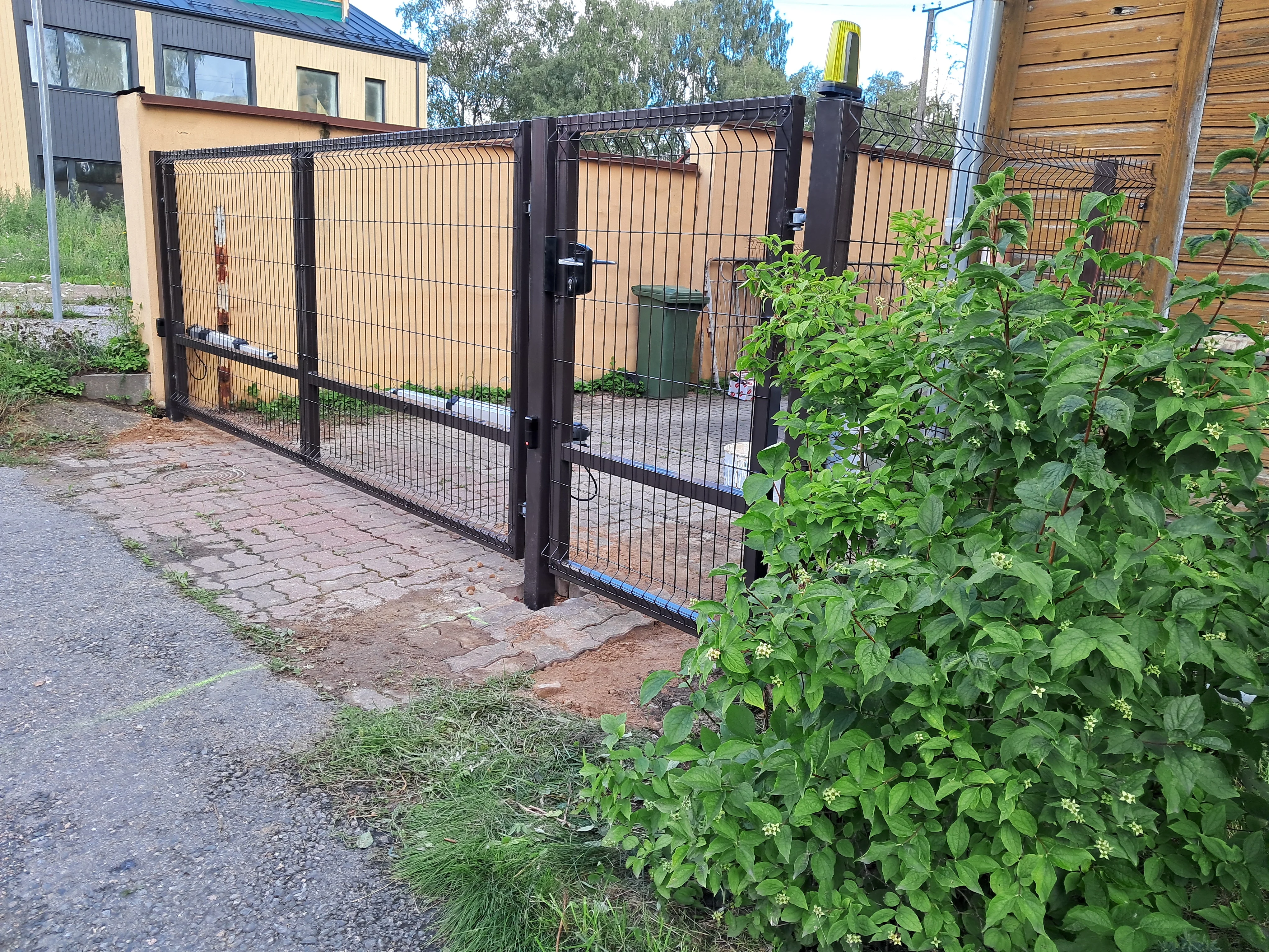 Värav - pruun keevispaneel liugvärav automaatikamootoritega hoovis