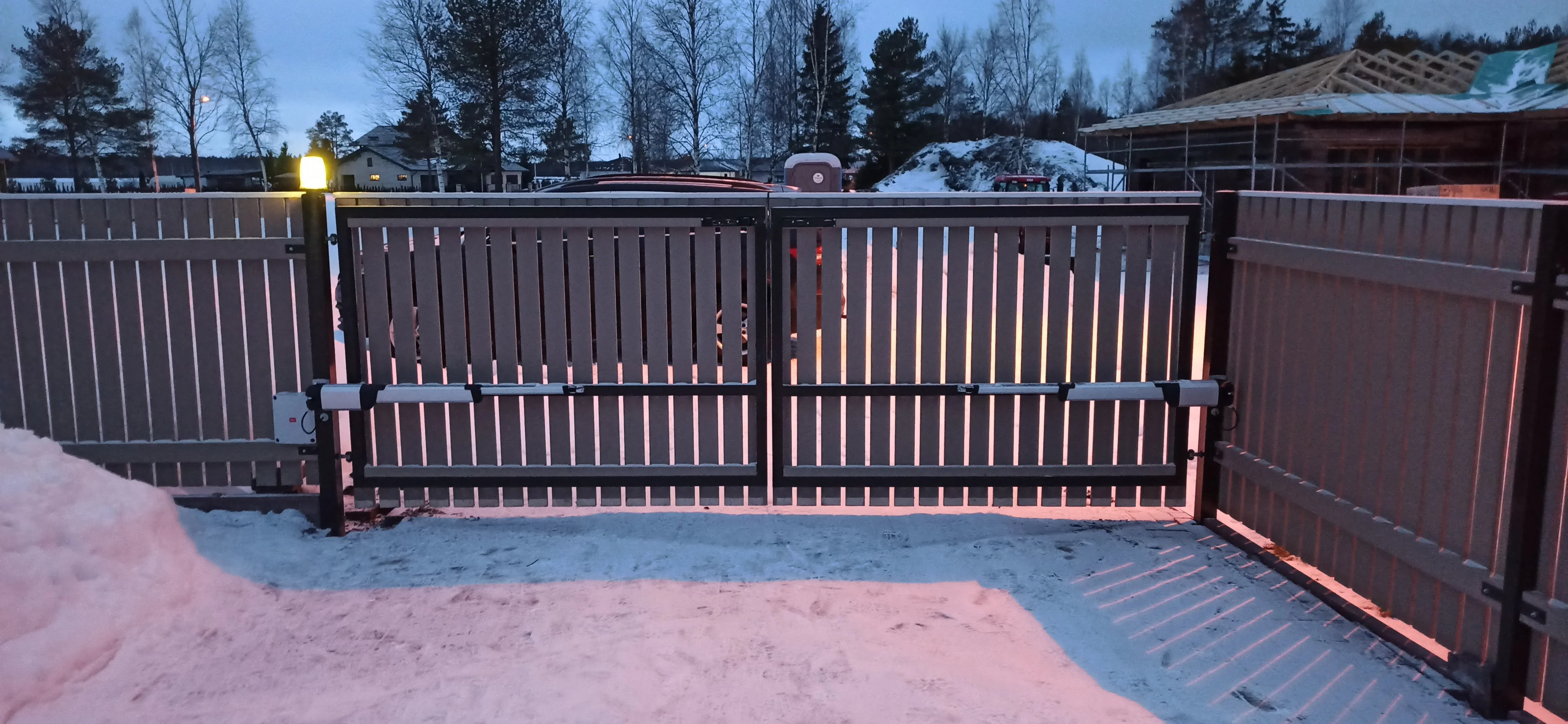 Värav - antratsiithall puitlaudis tiibvärav automaatikaga lumisel ööl